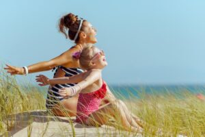 Woman and girl enjoying a sunny beach