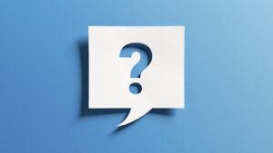 White paper question mark cutout over a light blue background