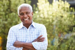 smiling older man outside enjoying having implant dentures