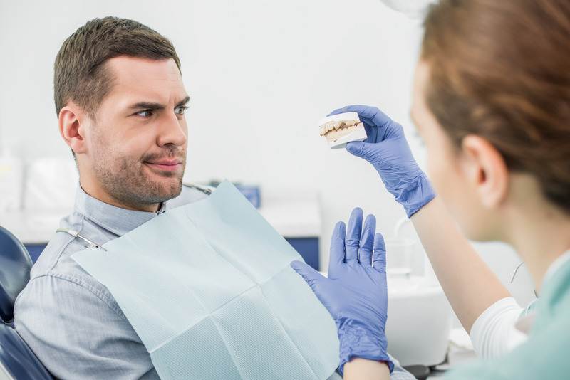 Dental implant patient talking to dentist about dentures